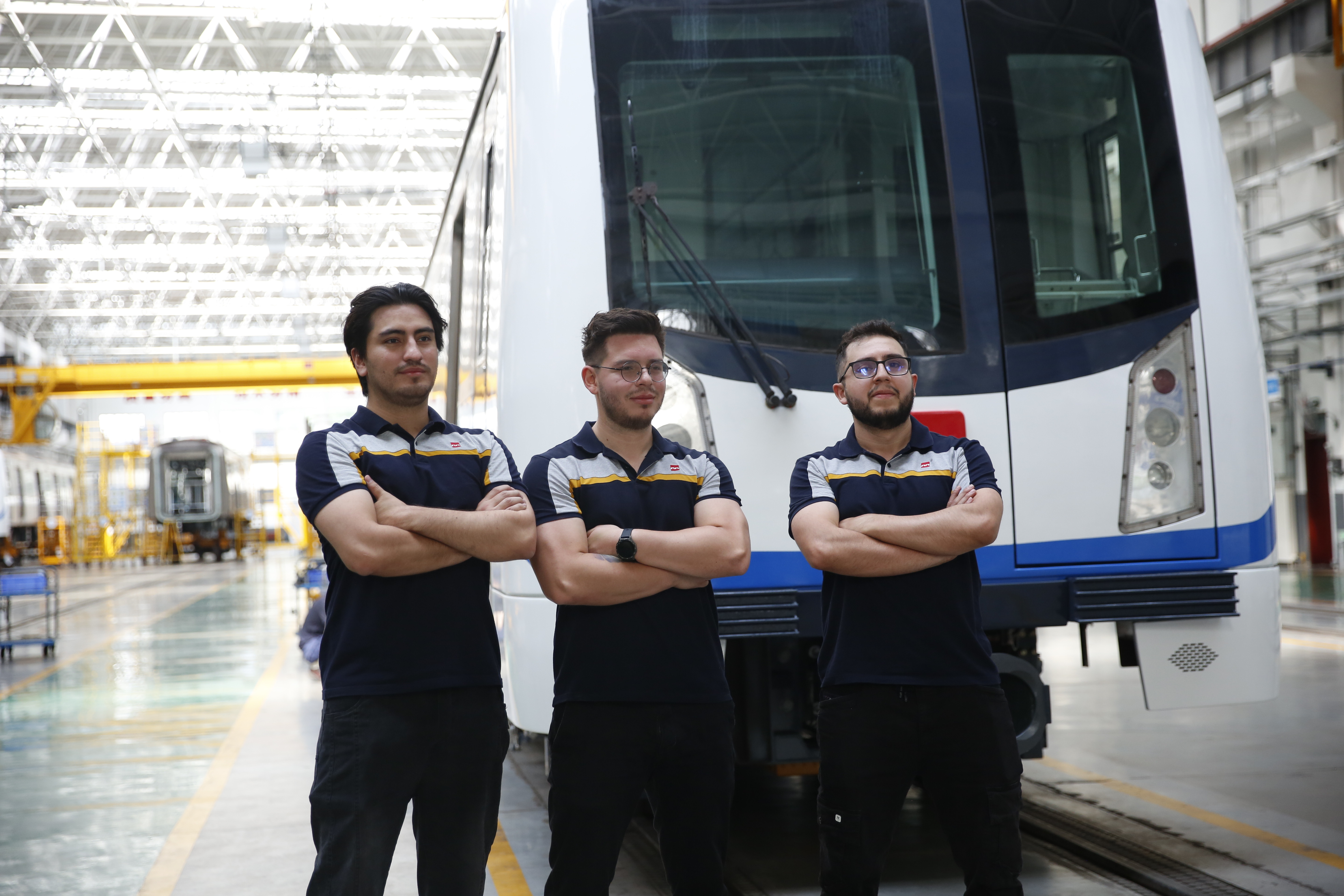 Jóvenes posando frente a un vagón en el patio taller en China