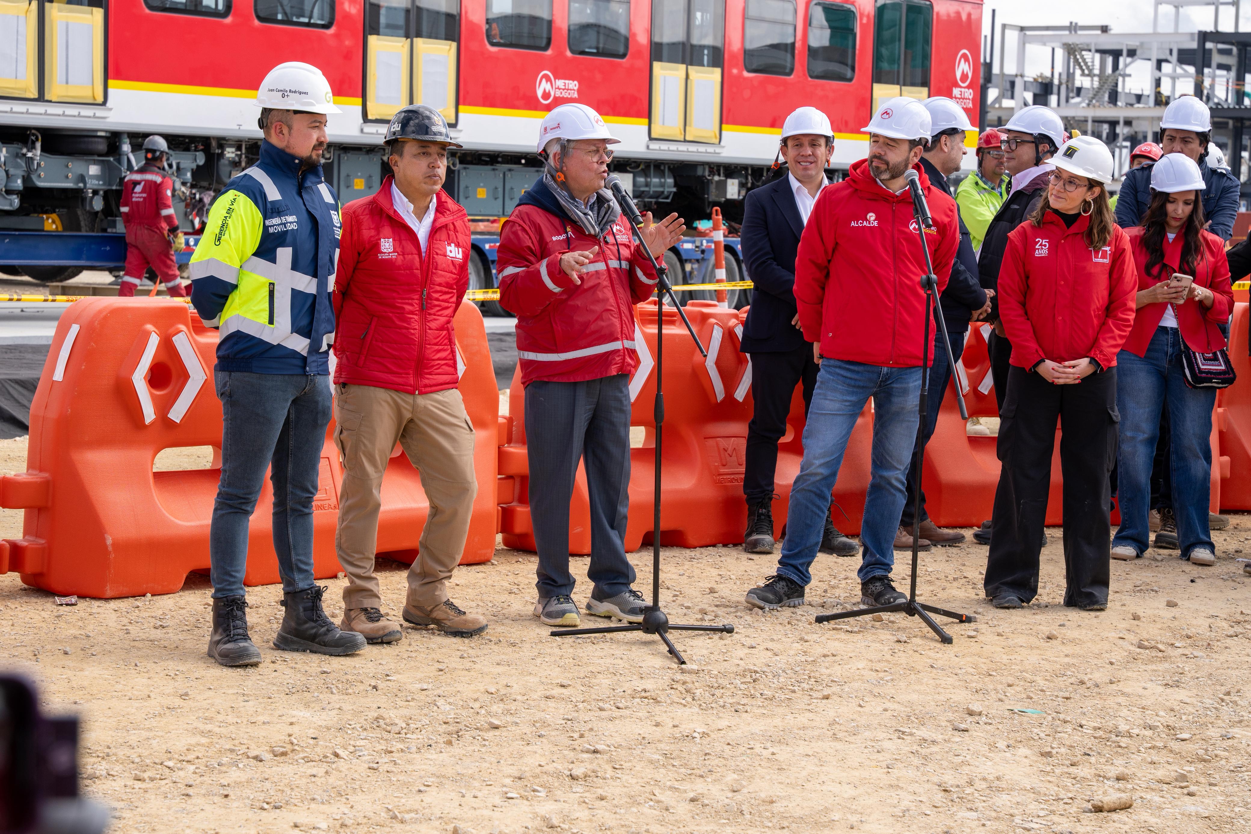 Frente al vagón del Metro descubierto en patio taller, están el gerente del Metro, el alcalde, la gerente de TransMilenio y el director del IDU dando declaraciones a los invitados del evento