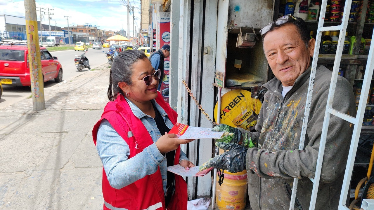 Funcionaria del Metro entrega volante a comerciante en las zonas cercanas a las obras del Metro